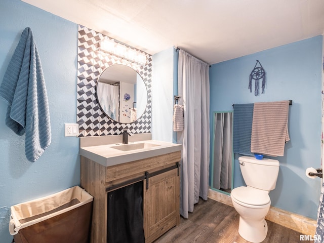full bathroom with toilet, baseboards, vanity, and wood finished floors