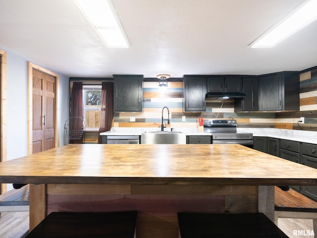 kitchen with wood counters, open shelves, appliances with stainless steel finishes, and a sink