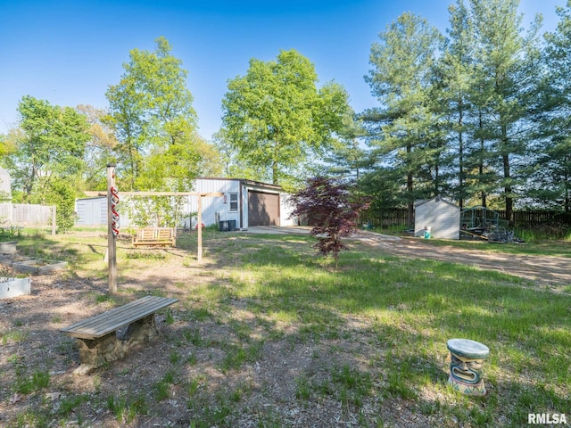 view of yard with an outbuilding, a shed, and fence