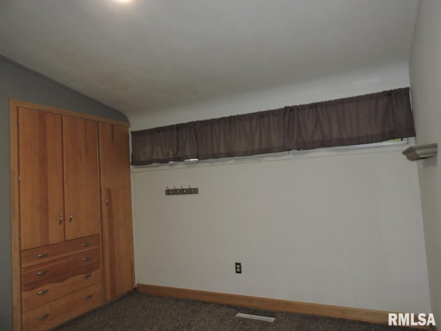 unfurnished bedroom featuring carpet flooring, lofted ceiling, and baseboards