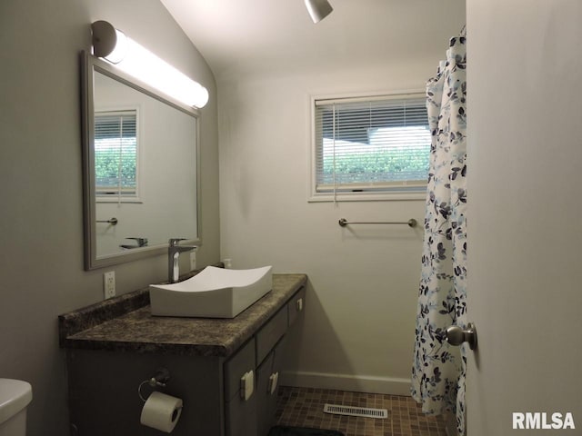 bathroom with plenty of natural light, vanity, toilet, and baseboards