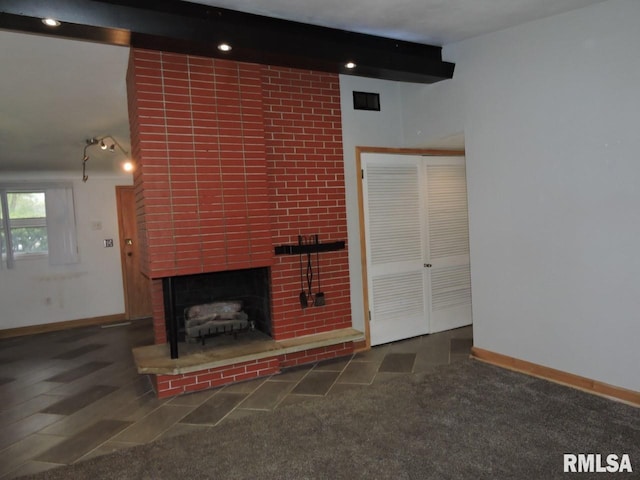 unfurnished living room featuring a brick fireplace and baseboards