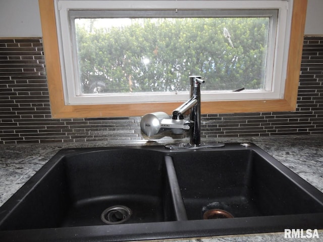 kitchen view of a sink and decorative backsplash