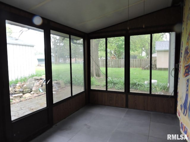 unfurnished sunroom with lofted ceiling and tile patterned flooring