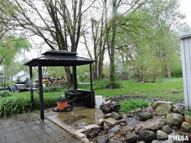 view of green lawn featuring a gazebo and a patio area