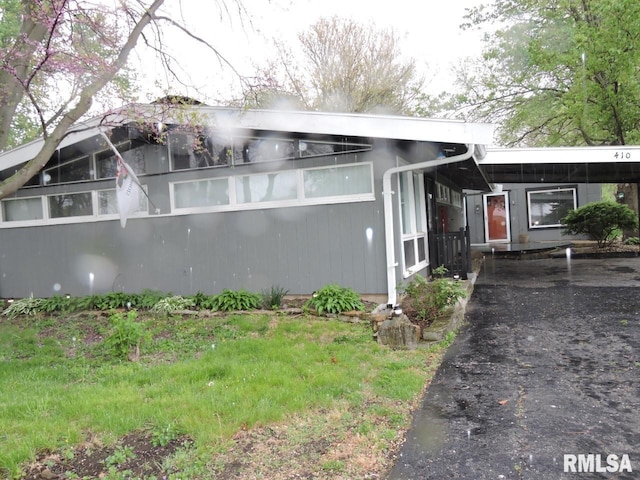 view of front of house featuring driveway and an attached carport