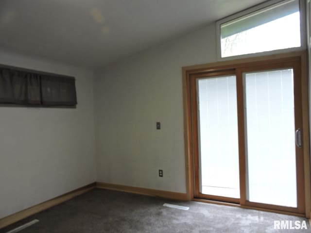 unfurnished room featuring dark colored carpet and baseboards