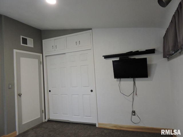 unfurnished bedroom featuring dark colored carpet and a closet