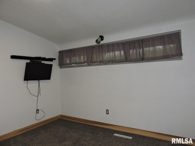 empty room with dark carpet and baseboards