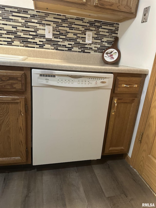 details featuring dark wood-style flooring, white dishwasher, tasteful backsplash, brown cabinets, and light countertops
