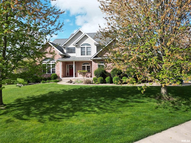craftsman inspired home featuring covered porch, a front lawn, and brick siding