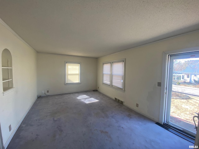 unfurnished living room featuring visible vents, a textured ceiling, baseboards, and carpet floors