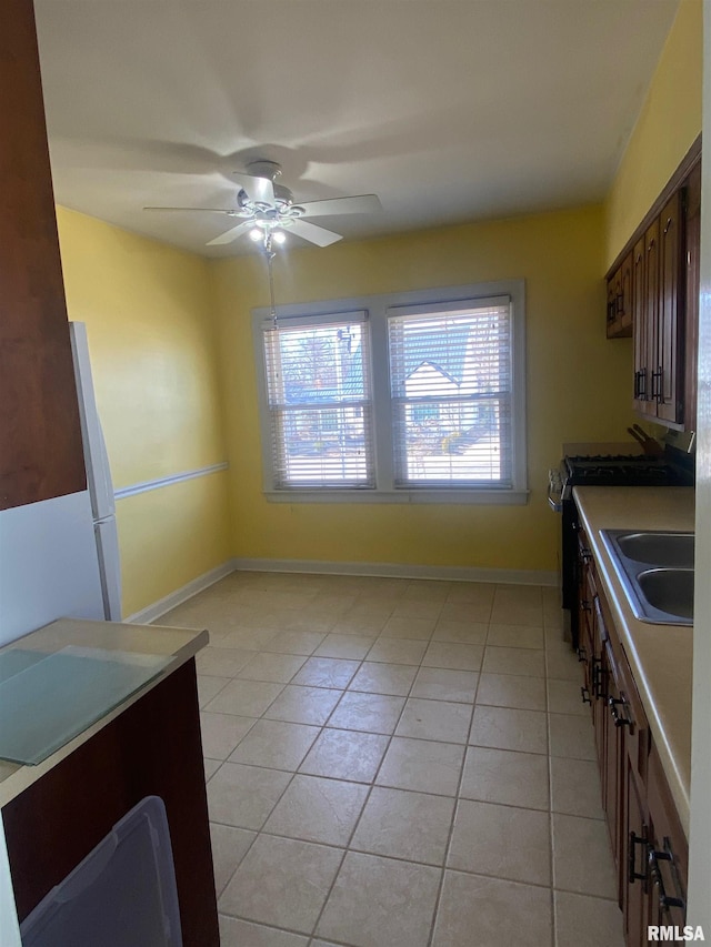 kitchen featuring light tile patterned floors, a ceiling fan, plenty of natural light, and a sink