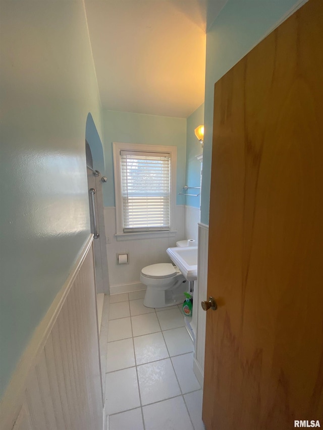 bathroom featuring tile patterned flooring, a shower, and toilet