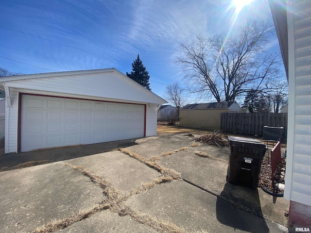 detached garage featuring fence and cooling unit