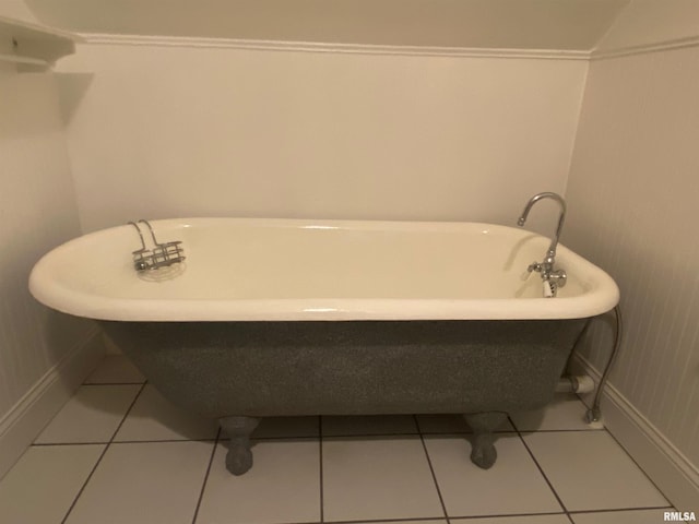 bathroom with baseboards, a soaking tub, and tile patterned floors