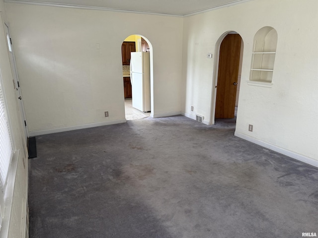 unfurnished room with crown molding, arched walkways, carpet flooring, and visible vents