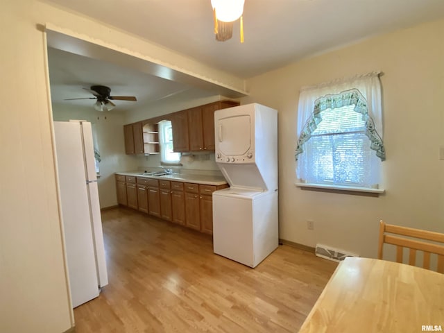 washroom with a sink, laundry area, stacked washing maching and dryer, visible vents, and ceiling fan