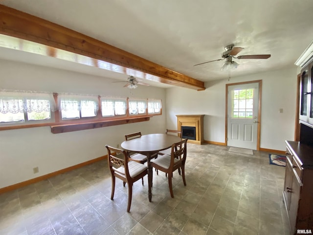dining area with baseboards, a fireplace, and ceiling fan