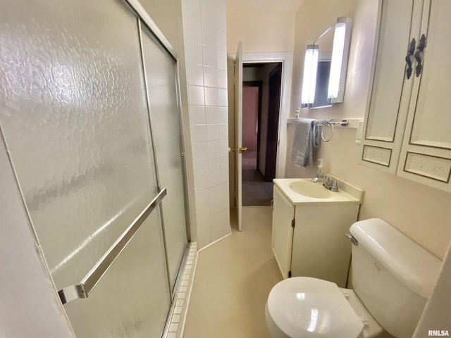 bathroom featuring vanity, toilet, and a stall shower