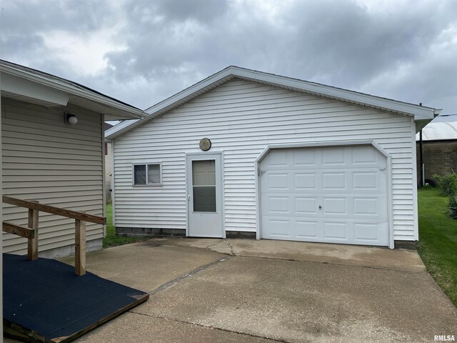 exterior space featuring concrete driveway, a detached garage, and an outdoor structure