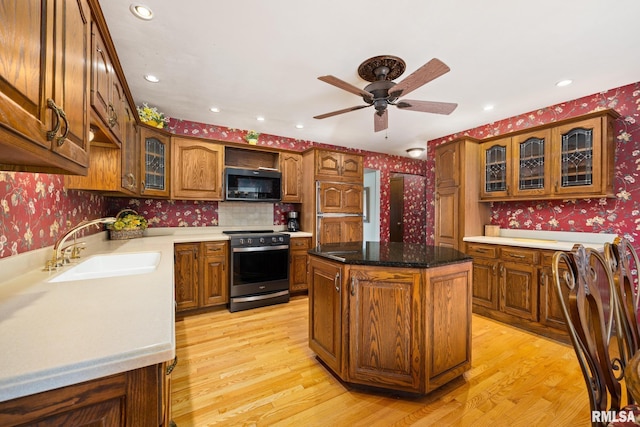 kitchen featuring wallpapered walls, stainless steel range with electric cooktop, and light wood-style floors