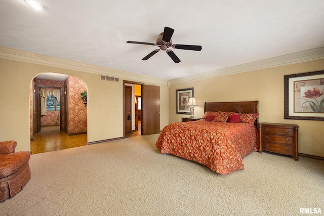 bedroom with carpet flooring, crown molding, visible vents, and arched walkways