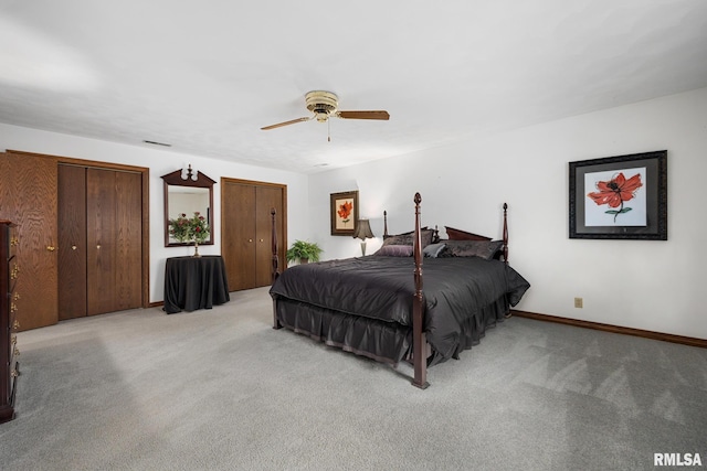 carpeted bedroom with ceiling fan, baseboards, multiple closets, and visible vents
