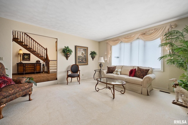 living area with stairway, visible vents, and carpet floors