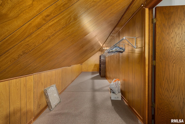 bonus room featuring lofted ceiling, wooden walls, and carpet flooring