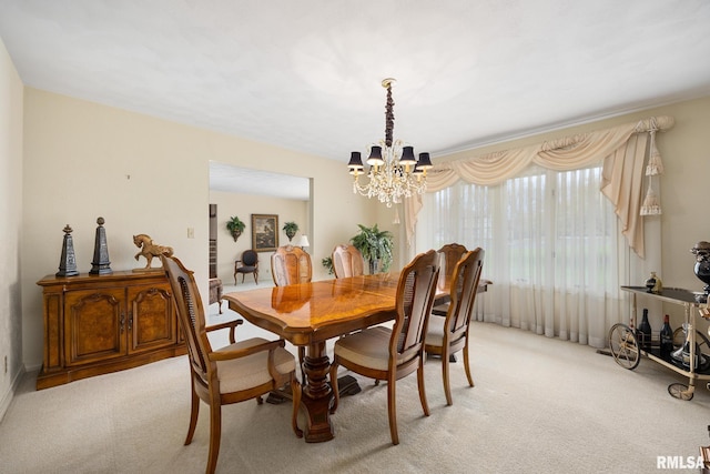 dining space featuring an inviting chandelier and light carpet