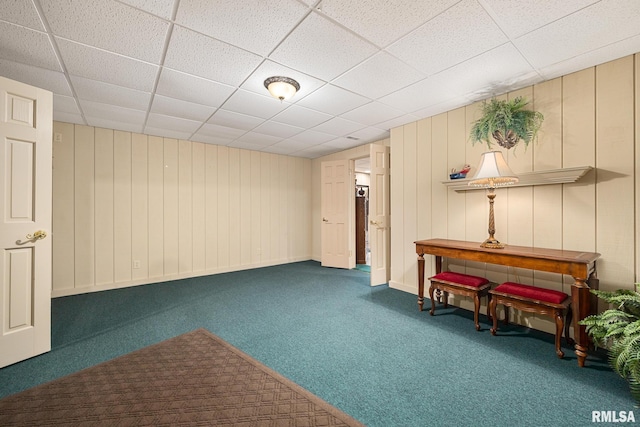 interior space featuring a paneled ceiling and carpet floors