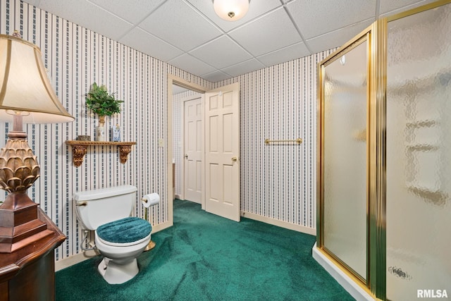 bathroom with toilet, carpet floors, a shower stall, a paneled ceiling, and wallpapered walls
