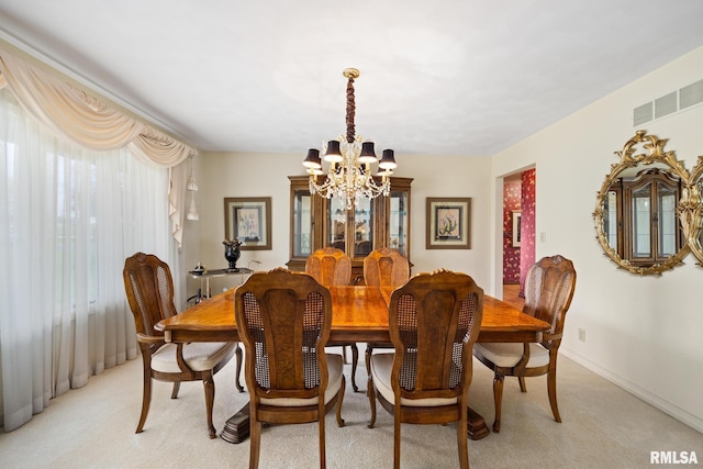 dining room featuring a chandelier, baseboards, visible vents, and light carpet