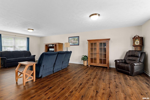 living area featuring dark wood-style floors, baseboards, and a textured ceiling