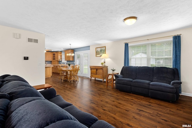 living area featuring dark wood-style floors, a textured ceiling, and baseboards