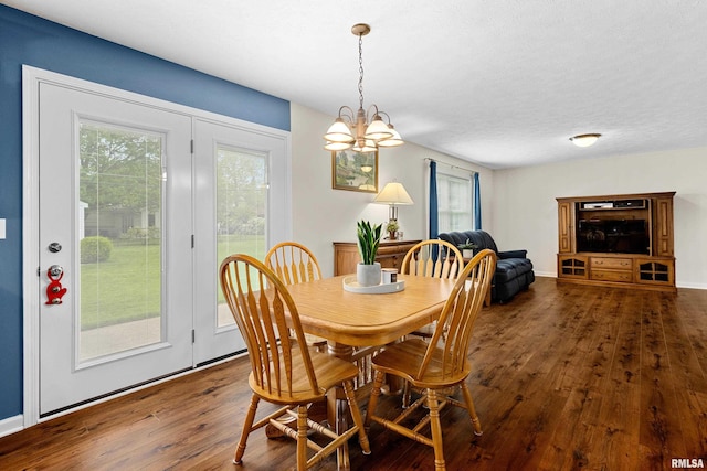 dining area featuring hardwood / wood-style floors, a chandelier, and baseboards