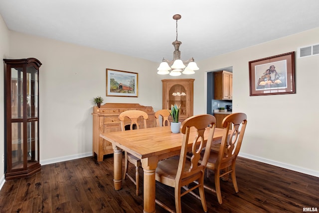 dining space featuring a chandelier, dark wood-type flooring, and baseboards