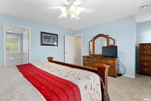 bedroom featuring light carpet, ensuite bath, ceiling fan, and baseboards