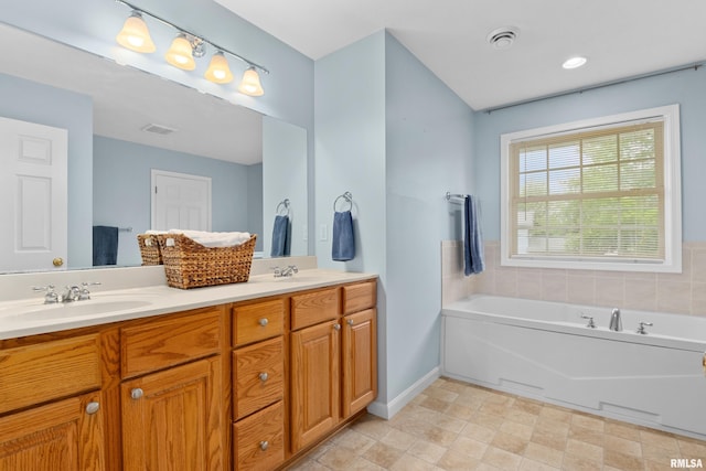 full bath featuring double vanity, a bath, and baseboards