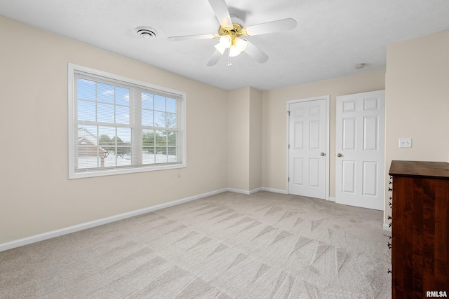 unfurnished bedroom featuring light colored carpet, baseboards, and ceiling fan