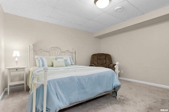 carpeted bedroom with baseboards and a drop ceiling