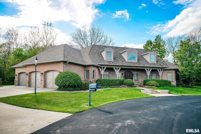 view of front of property with roof with shingles, an attached garage, brick siding, concrete driveway, and a front yard