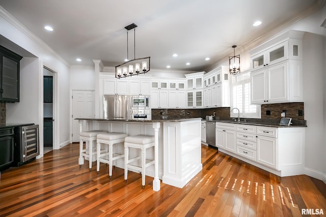 kitchen with beverage cooler, stainless steel appliances, a sink, and an inviting chandelier