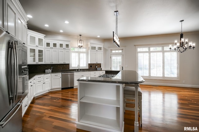 kitchen with ornamental molding, an inviting chandelier, appliances with stainless steel finishes, and a sink