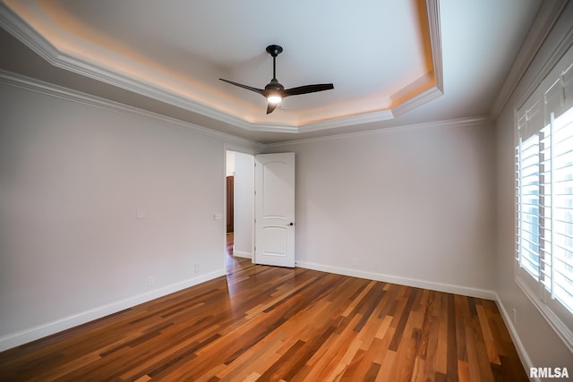 unfurnished room with a ceiling fan, baseboards, a tray ceiling, and wood finished floors