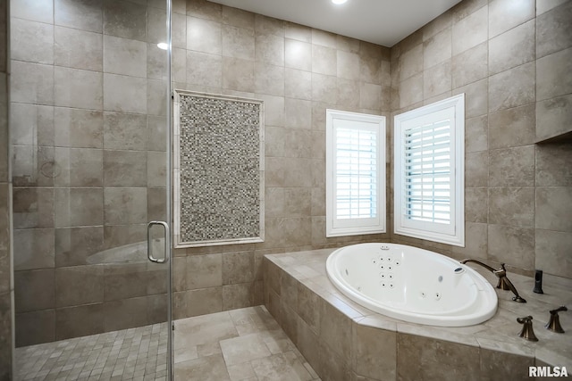 bathroom featuring a stall shower, tile walls, and a whirlpool tub