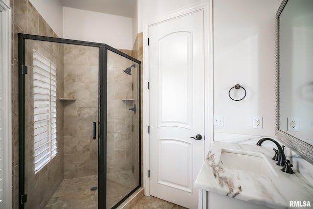 bathroom featuring a stall shower and a sink