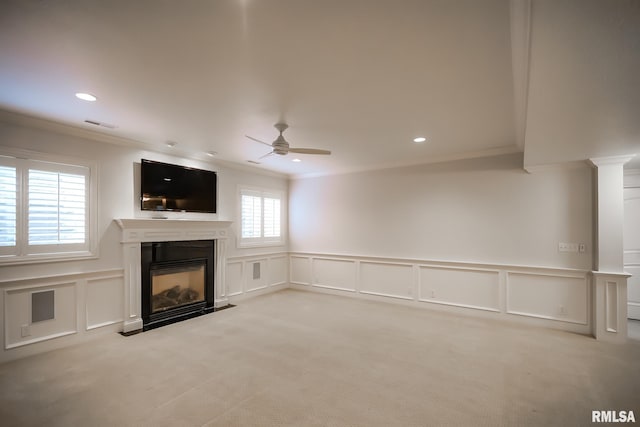 unfurnished living room featuring ornamental molding, light carpet, a decorative wall, and ceiling fan