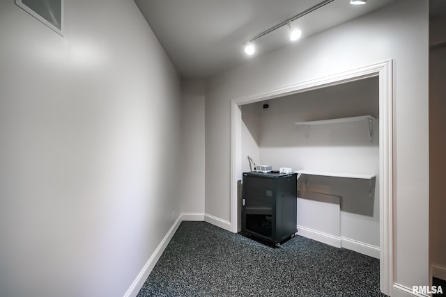 unfurnished office with baseboards and dark speckled floor